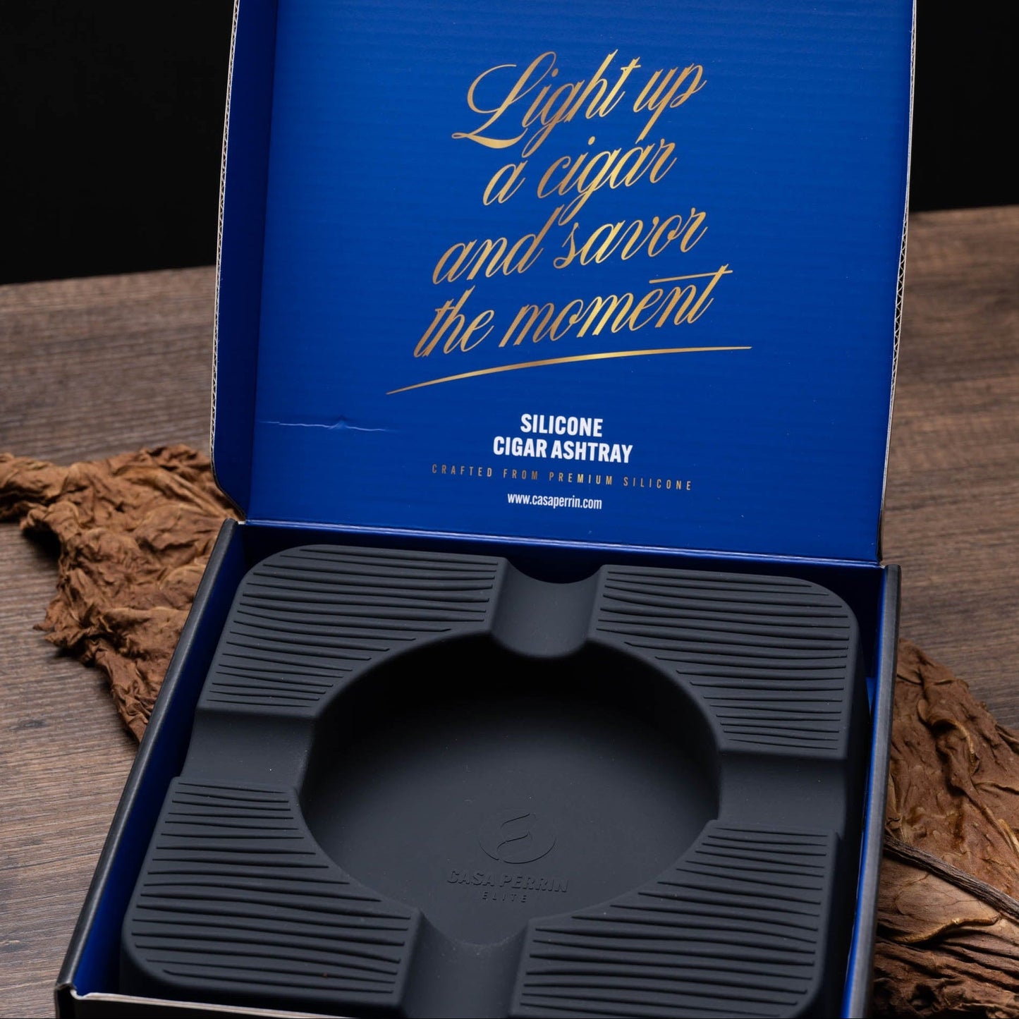 Silicone cigar ashtray in a blue packaging box on a wooden surface